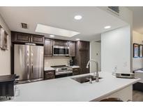 Bright kitchen with stainless steel appliances, gray counter tops, and a skylight for ample natural light at 18624 N 92Nd Dr, Peoria, AZ 85382