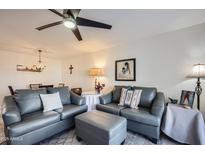 Inviting living room with stylish gray sofas, soft lighting, and views of the adjacent dining area at 18624 N 92Nd Dr, Peoria, AZ 85382