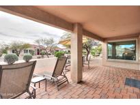 Inviting covered patio with brick flooring, lounge chairs, and views of the desert landscape at 2477 E Valencia Dr, Casa Grande, AZ 85194