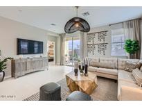 Bright living room with a modern sectional sofa, decorative lighting, and sliding doors to the backyard at 3266 E Baler Dr, San Tan Valley, AZ 85140