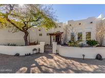 Charming desert home featuring a gated courtyard, lush landscaping, and unique architectural details at 44706 N 10Th Way, New River, AZ 85087