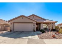 Charming single-story home showcasing a well-maintained front yard and attached two-car garage at 674 S 231St Dr, Buckeye, AZ 85326