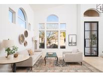 Bright and airy living room featuring vaulted ceilings, large windows, and stylish decor at 7357 E Rochelle Cir, Mesa, AZ 85207