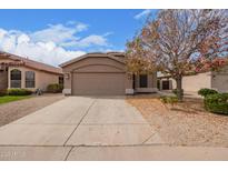 Charming single-story home with a well-maintained front yard, a two-car garage and desert landscaping at 1148 S Sierra St, Gilbert, AZ 85296