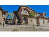 A charming two-story townhome shows southwest architecture, a front-entry staircase, a one-car garage, and a well-manicured xeriscaped front yard at 11500 E Cochise Dr # 2088, Scottsdale, AZ 85259