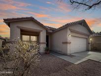 Charming single-story home featuring a two-car garage and low maintenance desert landscaping at 12017 N 151St Dr, Surprise, AZ 85379