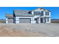 New two-story home featuring a three-car garage and gray and white color scheme with stone accents in a desert setting at 1510 E Red Range Way, Phoenix, AZ 85085