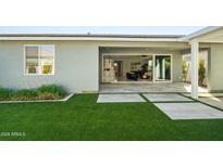 View of the backyard with manicured artificial turf and patio at 17192 W Rocklin St, Surprise, AZ 85388