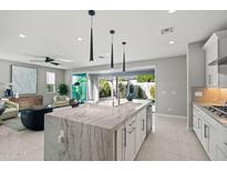 Open kitchen features a large center island, modern pendant lighting, and stainless steel appliances at 17192 W Rocklin St, Surprise, AZ 85388