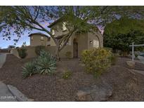 Charming two-story home with stucco facade, gated courtyard, and desert landscaping at dusk at 18256 W Carol Ave, Waddell, AZ 85355