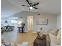 Bright, open living room with vaulted ceiling, modern fan, and neutral decor at 18359 N 88Th Ave, Peoria, AZ 85382