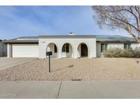 Charming home featuring an arched entryway, a two-car garage and desert landscaping at 19236 N 22Nd Ln, Phoenix, AZ 85027