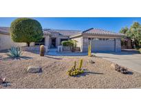 Charming single-story home showcasing desert landscaping, stone accents, and a well-maintained front yard at 19460 N Hidden Canyon Dr, Surprise, AZ 85374