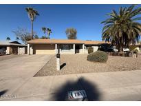 Charming single-story home with desert landscaping, mature palm trees, and a two-car garage at 1954 W Kerry Ln, Phoenix, AZ 85027