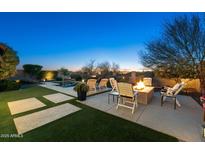 Inviting backyard with a fire pit, lounge chairs and sparkling pool at dusk at 2046 N Red Clf, Mesa, AZ 85207