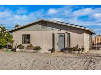 Charming single-story home showcasing a gravel front yard, cozy front porch and neutral color palette at 330 W Northern Ave, Coolidge, AZ 85128