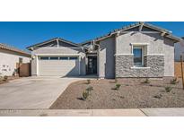 Charming single-story home with a stone accent wall, desert landscaping, and a two-car garage at 3382 E Saddletree Way, San Tan Valley, AZ 85140