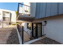 Condo exterior featuring a small balcony and basement-level doorway entrance and black metal banisters at 3416 N 44Th St # 70, Phoenix, AZ 85018