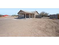 The property features a spacious dirt front yard, covered parking, and block fencing, offering privacy and functionality at 3545 N Hohokam Dr, Eloy, AZ 85131