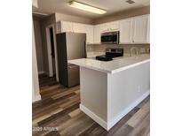 Bright kitchen features white cabinets, stainless steel appliances, and modern countertops at 510 N Alma School Rd # 103, Mesa, AZ 85201