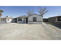 Charming single-story home featuring a low-pitched roof, white stucco, dark trim and a large front yard at 6029 S 6Th Ave, Phoenix, AZ 85041