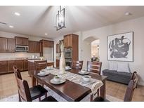 Formal dining room showcasing dark wood table and decor with views into the kitchen at 9556 W Frank Ave, Peoria, AZ 85382