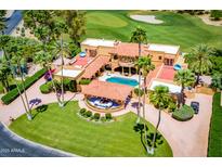 Expansive estate with terracotta roofs, a pool, and a landscaped yard bordering a verdant golf course at 7155 E Oakmont Dr, Paradise Valley, AZ 85253