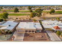 An aerial view of a home in a golf community, featuring a well-maintained exterior and surrounding greenery at 10818 W Palmeras Dr, Sun City, AZ 85373