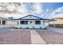 Charming single-story home featuring a pristine white exterior and a beautifully landscaped front yard at 1133 E 4Th St, Casa Grande, AZ 85122