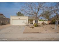 Charming single-story home featuring a two-car garage and desert landscaping at 1220 E Utopia Rd, Phoenix, AZ 85024