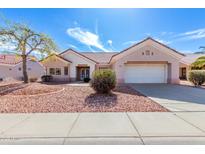 Charming single-story home featuring a desert landscape, a two-car garage, and a beautiful red tile roof at 14608 W Horizon Dr, Sun City West, AZ 85375