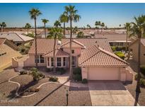 Beautiful home showcasing a desert landscape, tile roof, and an attached two-car garage at 14817 W Domingo Ln, Sun City West, AZ 85375