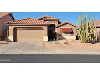 Charming single-Gathering home features a two-car garage, red tile roof, and xeriscaped front yard with desert landscaping at 18080 W Udall Dr, Surprise, AZ 85374