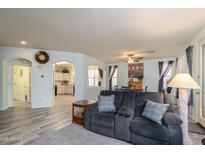 Inviting living room featuring an open floor plan and modern gray flooring at 18080 W Udall Dr, Surprise, AZ 85374