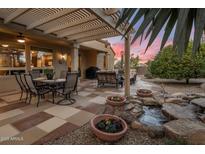 Charming outdoor space featuring a pergola, seating, and a lovely water feature at 18400 N Deer Grass Ct, Surprise, AZ 85374