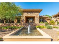 Attractive entrance to The Edge with water feature and stone facade under a bright blue sky at 20100 N 78Th Pl # 1104, Scottsdale, AZ 85255