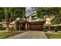 Charming two-story home boasts a brick driveway and lush landscaping at 4064 E Morrison Ranch Pkwy, Gilbert, AZ 85296