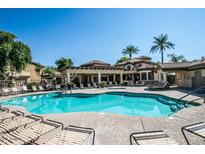 Community pool and clubhouse featuring plenty of seating on a sunny day at 10136 E Southern Ave # 2062, Mesa, AZ 85209