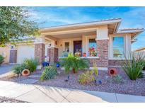 Inviting front porch features decorative brick accents and colorful potted plants for a cheerful welcome at 10545 E Texas Ave, Mesa, AZ 85212