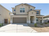 Two-story home featuring a neutral color scheme, two-car garage and a well-manicured yard with desert landscaping at 17745 W Carol Ave, Waddell, AZ 85355