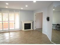 Bright living room with tile floors, fireplace, shutters, and access to outdoor balcony at 4303 E Cactus Rd # 331, Phoenix, AZ 85032