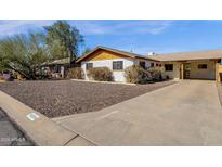 Charming single-story home with a rock yard, covered carport and white painted brick at 6934 E Coronado Rd, Scottsdale, AZ 85257