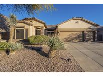 Charming single-story home with desert landscaping, stone accents, and three-car garage at 7149 E Quartz St, Mesa, AZ 85207