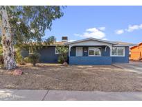 Charming single-story home featuring a well-maintained yard, blue paint, and a cozy front porch at 14820 N 35Th St, Phoenix, AZ 85032