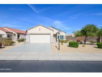 Charming single-story home features a well-maintained desert landscape and a two-car garage at 15770 W Remington Dr, Surprise, AZ 85374