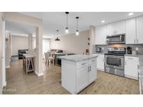 Bright kitchen with white cabinets, stainless steel appliances, granite countertops and a center island at 16041 N 31St St # 21, Phoenix, AZ 85032