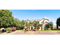 Attractive home exterior featuring mature landscaping, palm trees, and a welcoming front facade at 6960 E Ivyglen St, Mesa, AZ 85207