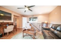 Cozy living area with wood floors, ceiling fan, and comfortable seating at 834 S Beryl Dr, Apache Junction, AZ 85119