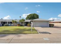 Charming single-story home featuring a well-manicured lawn and a two-car garage at 10303 W Desert Forest N Cir, Sun City, AZ 85351
