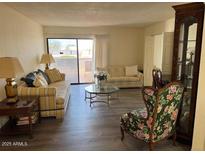 Comfortable living room with large windows and bright neutral decor at 17404 N 99Th Ave # 136, Sun City, AZ 85373